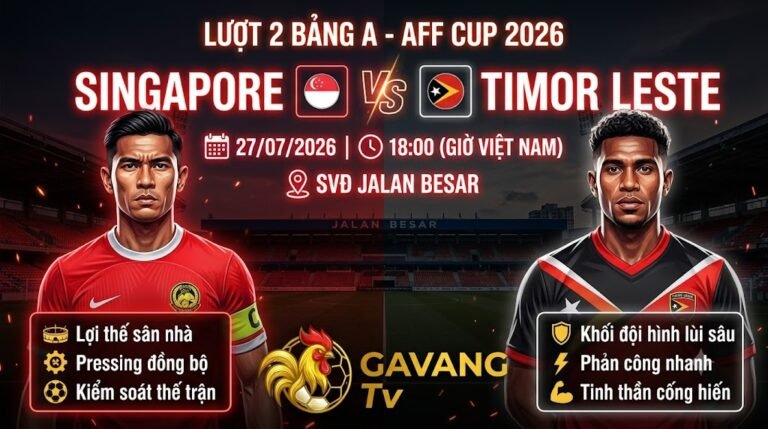 Ảnh bìa nhận định trận đấu Singapore vs Timor Leste ở AFF Cup 2026, với tông màu đỏ (Singapore) và tông màu trắng/đen/đỏ (Timor Leste) được chia cắt rõ ràng. Chữ neon lớn ghi 'LƯỢT 2 BẢNG A - AFF CUP 2026', 'SINGAPORE vs TIMOR LESTE', kèm thời gian và địa điểm. Cầu thủ Hariss Harun của Singapore và Joao Pedro của Timor Leste hiện lên mạnh mẽ, kèm các điểm nhấn chiến thuật cho mỗi đội. Logo Gavang TV ở dưới cùng.